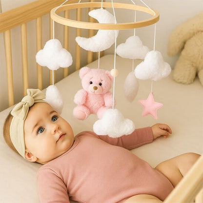 Mobile de lit bébé étoilé avec un ours en peluche, nuages et étoile, créant un univers apaisant pour le nouveau-né.